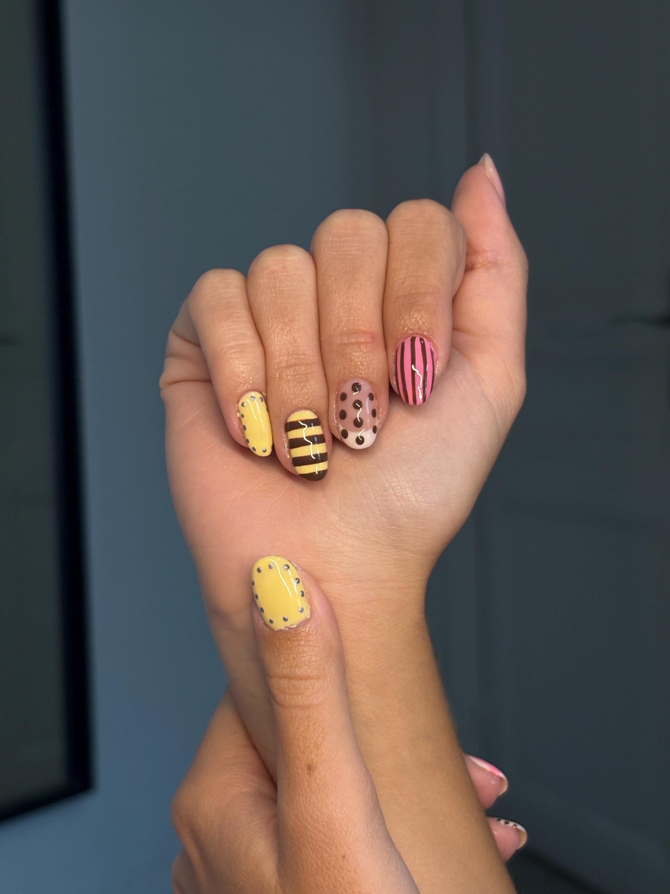 Press on nail with polka dot and stripe motifs in pink, yellow, brown and white